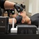 Una mujer se relaja en un sillón de salón y le dan forma a sus cejas mientras usa parches oculares de hidrogel para mayor comodidad.