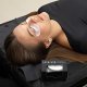Una mujer se relaja en una cama con los ojos cerrados, mientras los parches oculares de hidrogel realzan su belleza durante la aplicación de la extensión de pestañas.